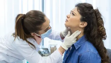 Lékař zkoumá krk pacientky při vyšetření slinných žláz.