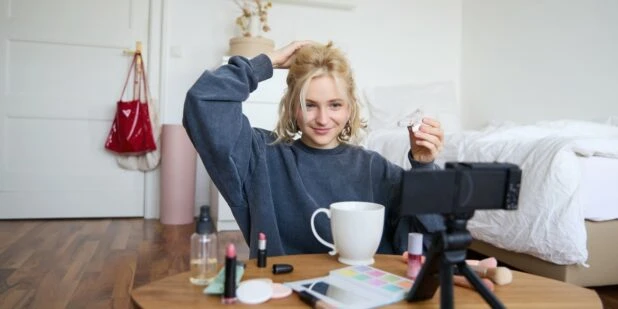 mladá žena natáčí make-up tutorial pro sociální sítě