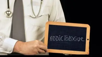 Doctor holding chalkboard with addictologue text