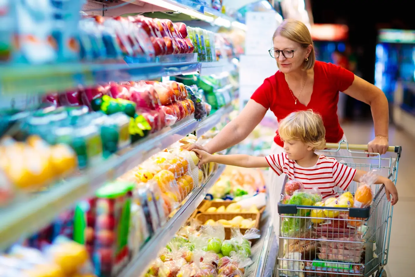 Žena s dítětem nakupují ovoce v supermarketu.