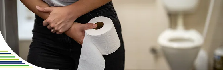 Člověk drží v rukou roli toaletního papíru ve vaně.