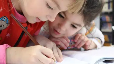 Dvě děti kreslí společně v sešitu.