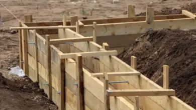 Dřevěné ztracené bednění pro betonovou základnu v příkopu.