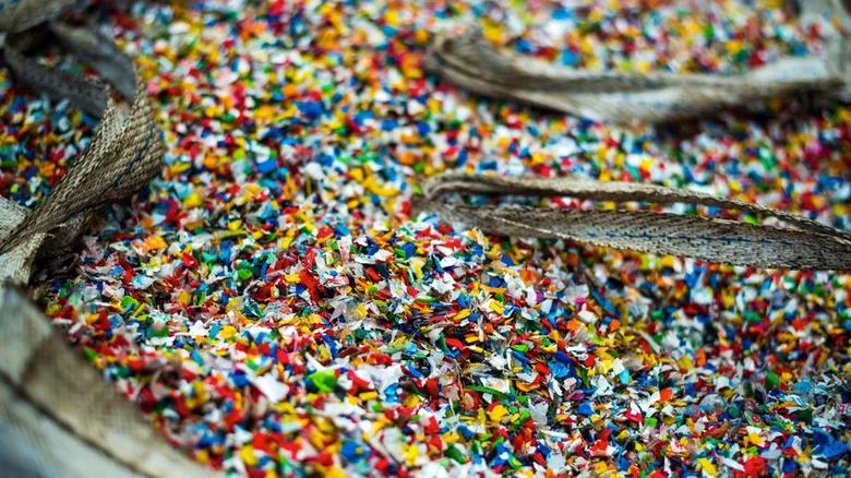 Hromada barevných mikroplastů v otevřené tašce.