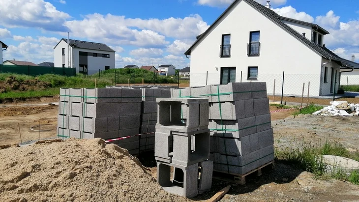 Skládané ztracené bednění na staveništi s pískem v pozadí.