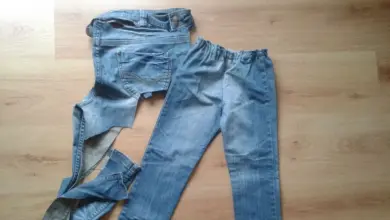Staré džíny položené na podlaze připravené k recyklaci.