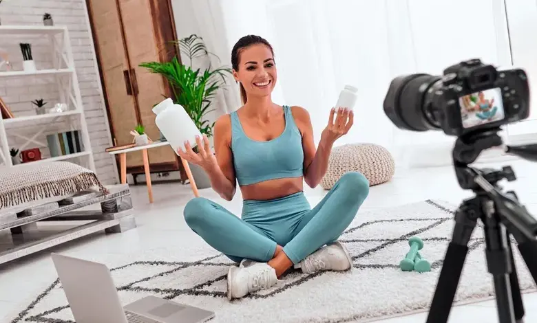 Žena v sportovním oblečení natáčí video s doplňky stravy pro sociální síť.