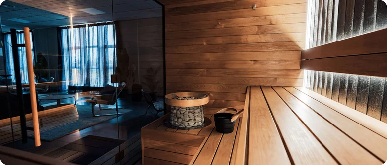 Sauna s dřevěnými lavicemi a kamenem pro parní lázeň