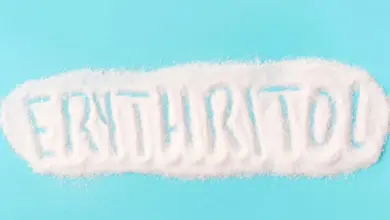 Bílý prášek s nápisem erythritol na modrém pozadí.