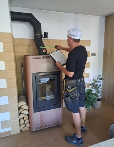 Technik provádí revizi komína u krbu s dokumentací.