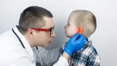 Lékař vyšetřuje dítě s bolestivým uchem.