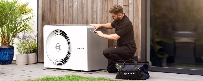 Instalace tepelného čerpadla technikem na venkovním podloubí.