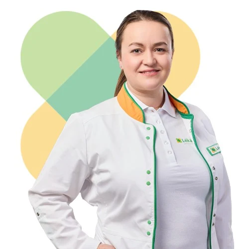 Žena v lékařském plášti se usmívá na pozadí srdce.